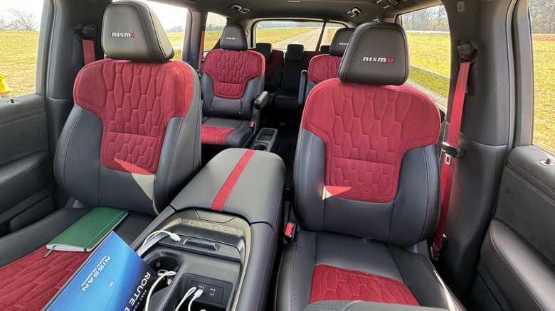 A look back at the red and black quilted seats in the Armada Nismo with grass out the windows