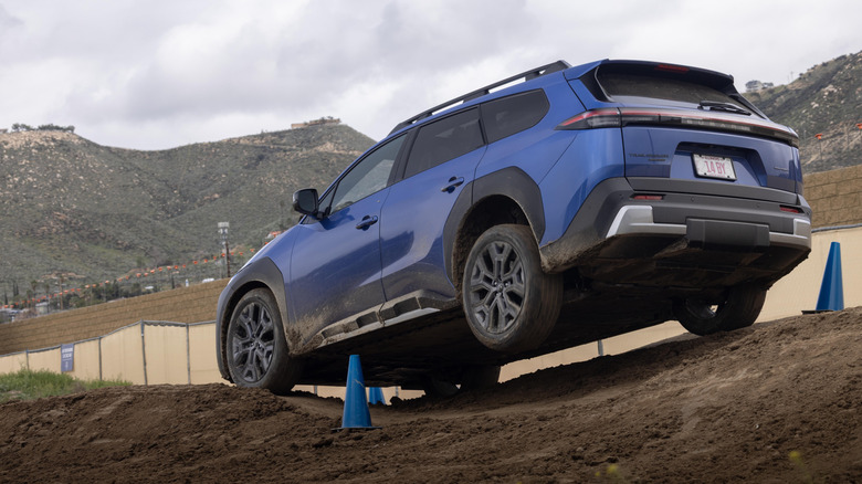 Rear 3/4 view of a blue Subaru Trailseeker on an off-road course