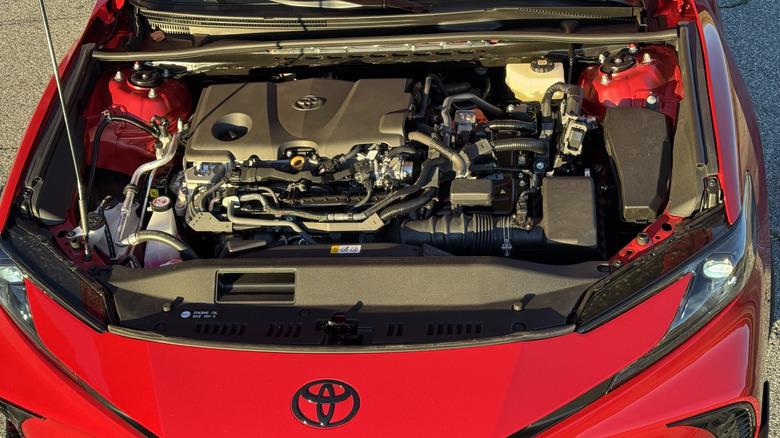 A look under the hood of the red Camry Nightshade parked on asphalt