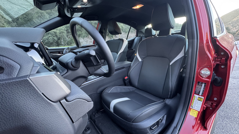 A look in the driver's door at the black interior with some white accents in the red Camry