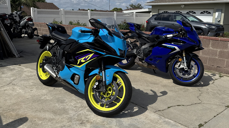 A blue, purple, and yellow Yamaha R7 next to a blue Yamaha R9 in a driveway