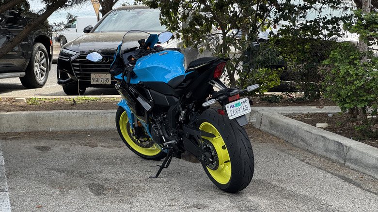 A blue, purple, and yellow Yamaha R7 in a parking space from the rear