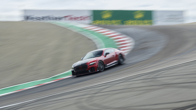 A red and black 2027 Bentley Supersports going through the corkscrew