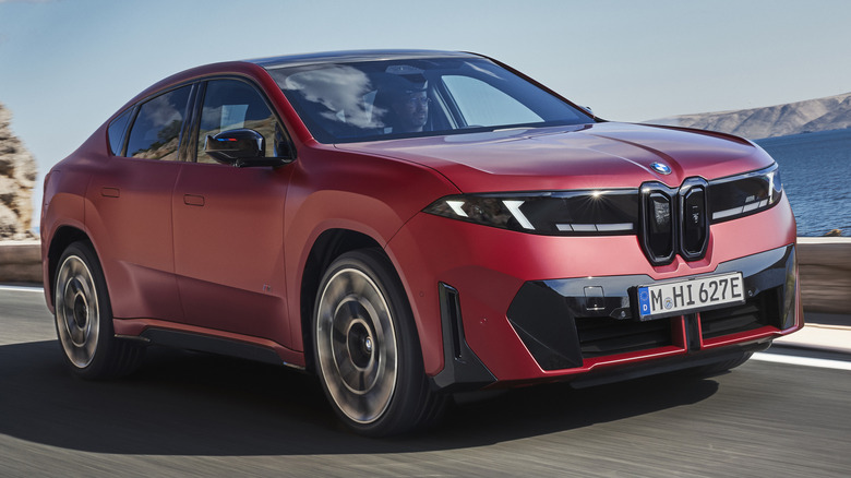Front 3/4 view of a satin red 2027 BMW iX4 M60