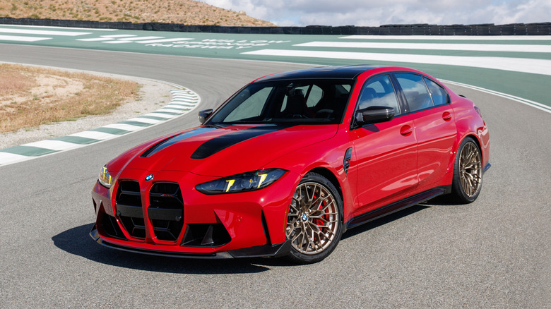 Front 3/4 view of an Imola Red 2027 BMW M3 CS on track