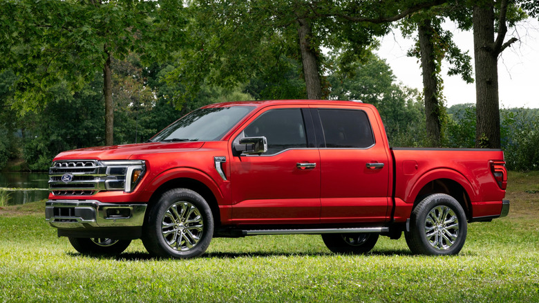 2027 Ford F-150 Lariat side profile parked on grass in front of trees