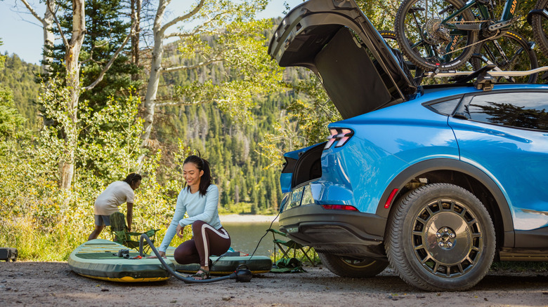 A blue 2027 Ford Mustang Mach-E Trail being used to power an air compressor