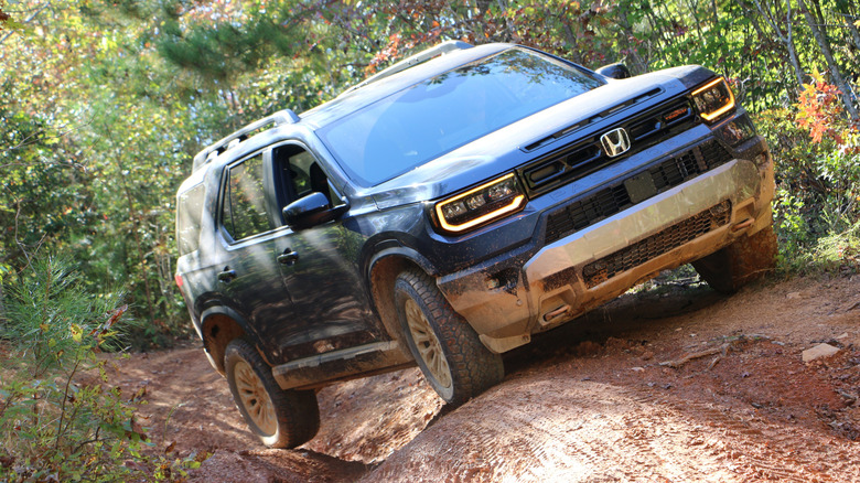 2027 Honda Passport TrailSport front 3/4 view off-roading at OEX in North Carolina