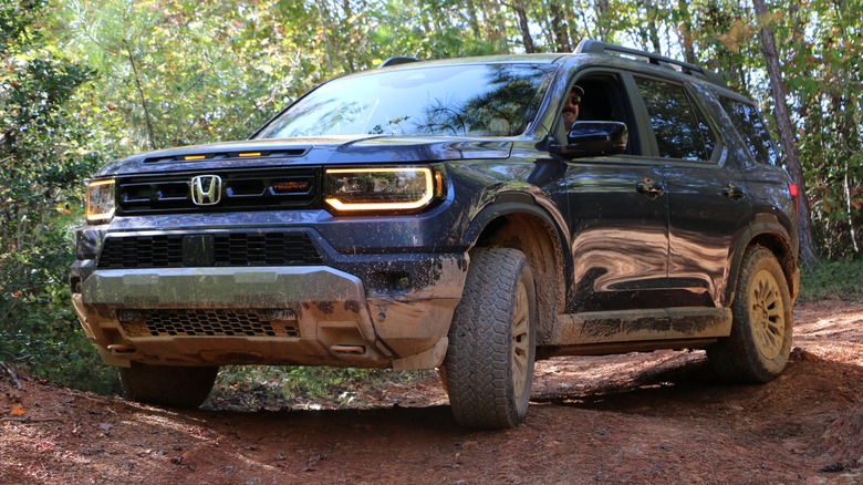 2027 Honda Passport TrailSport front 3/4 view off-roading at OEX in North Carolina with Andy Kalmowitz behind the wheel