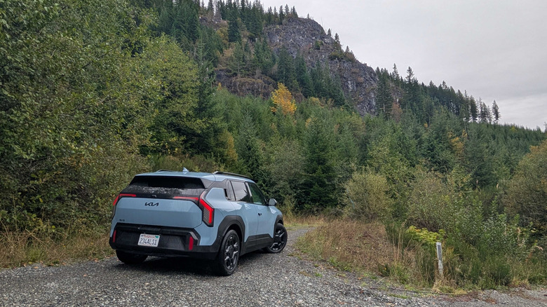 2027 Kia EV3 parked in front of a mountain covered in trees
