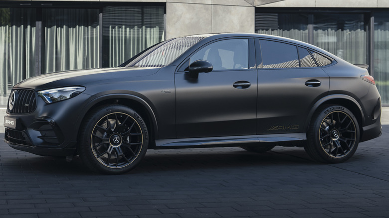 A side view of a matte black AMG GLC53 with the Golden Accents Package showing the gold on the wheels and the subtle AMG badge on the rear doors