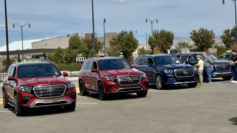 Wide shot of the front of four different GLS models parked next to eachother with two red standard GLS on the left, a dark blue GLS63, and a dark colored GLS behind it