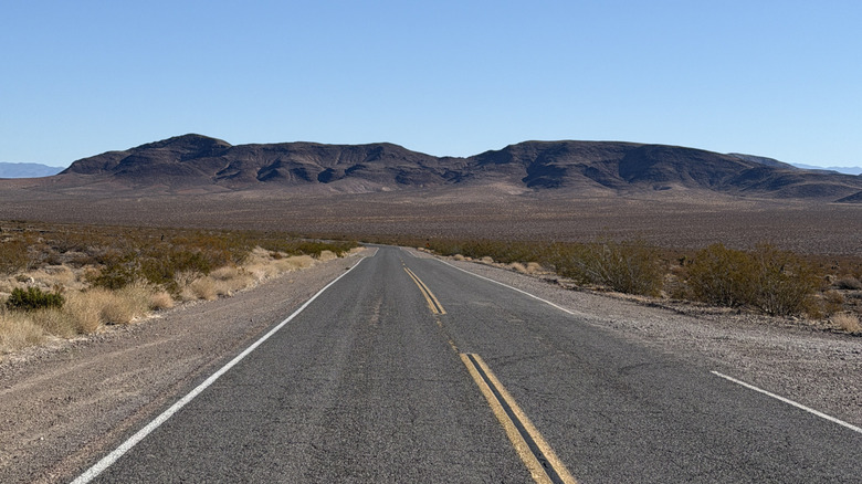 A desert road in California with mountains in the distance