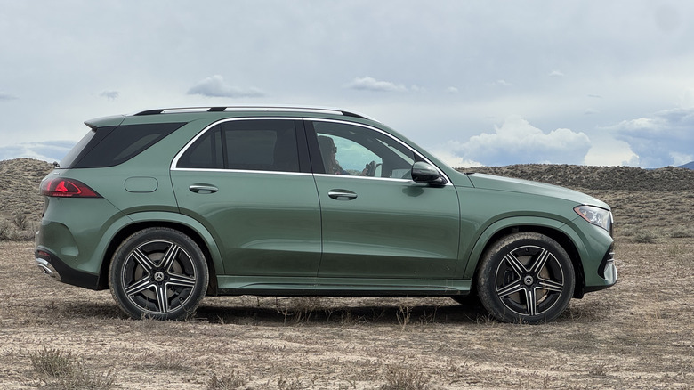 A side view of the green GLE500e parked on dirt in front of a cloudy sky