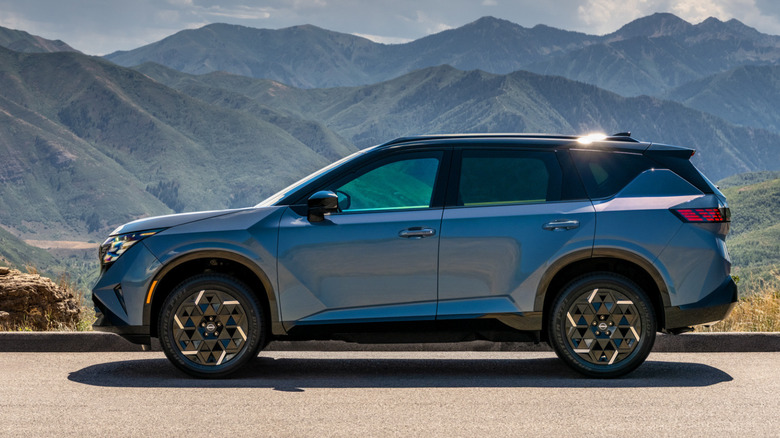 Side view of a blue 2027 Nissan Rogue Hybrid