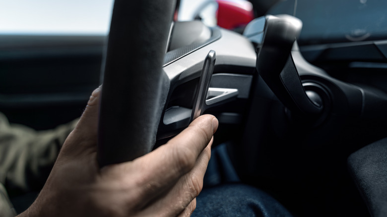 A finger pulling a paddle shifter on a 2027 Porsche Taycan