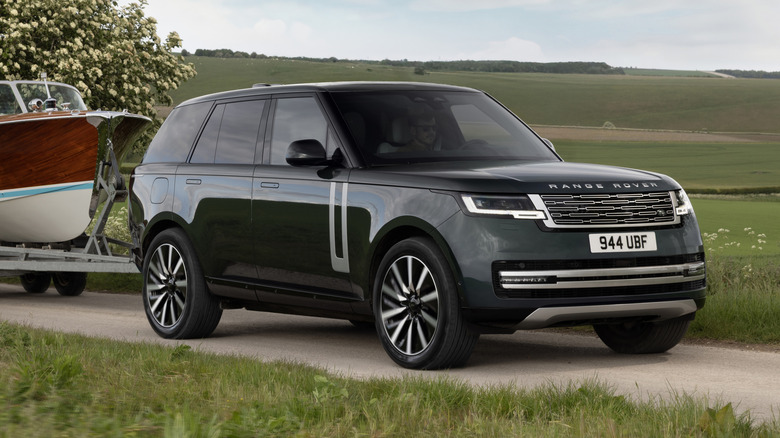 Front 3/4 view of a green Range Rover EV towing
