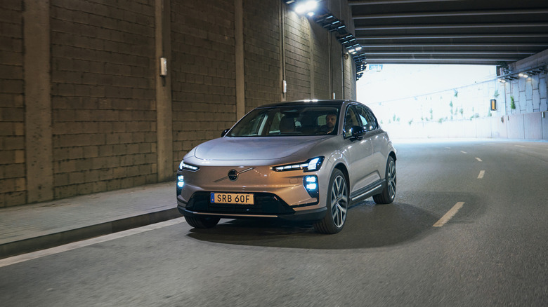 A silver 2027 Volvo EX60 driving through a tunnel