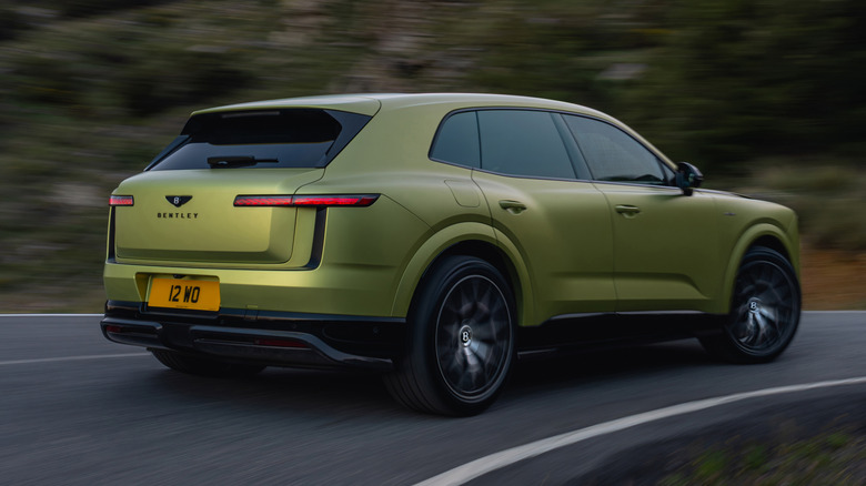 Rear 3/4 view of a green Bentley Torcal driving
