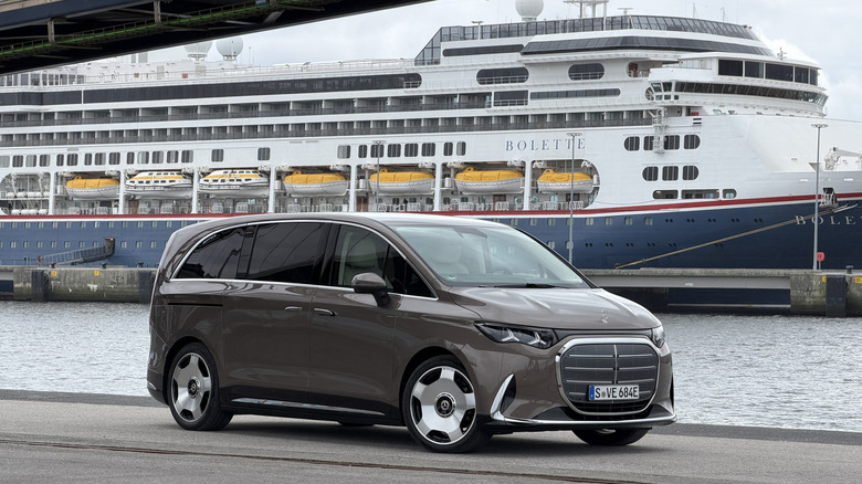 Front 3/4 view of a brown Mercedes-Benz VLE in front of a cruise ship