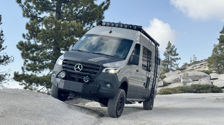 A front three quarters shot of the Beastmode XO with its front passenger side wheel propped up on a rock in front of more rocks and trees