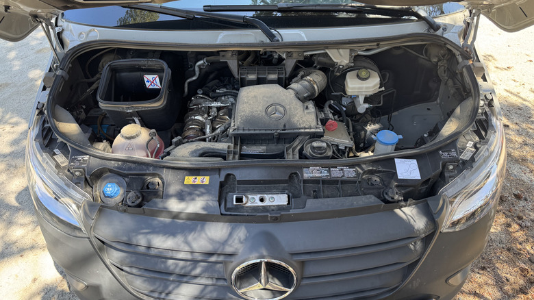 An underhood shot showing the tiny Mercedes diesel in an otherwise rather bare engine bay