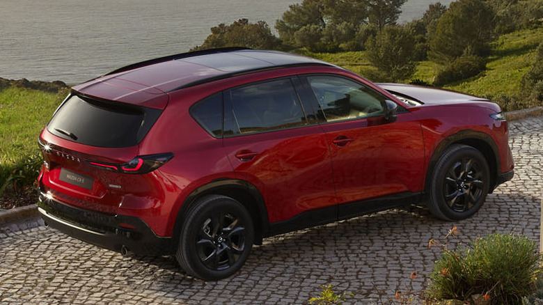 A red 2026 Mazda CX-5 parked on paving stone drive overlooking harbor