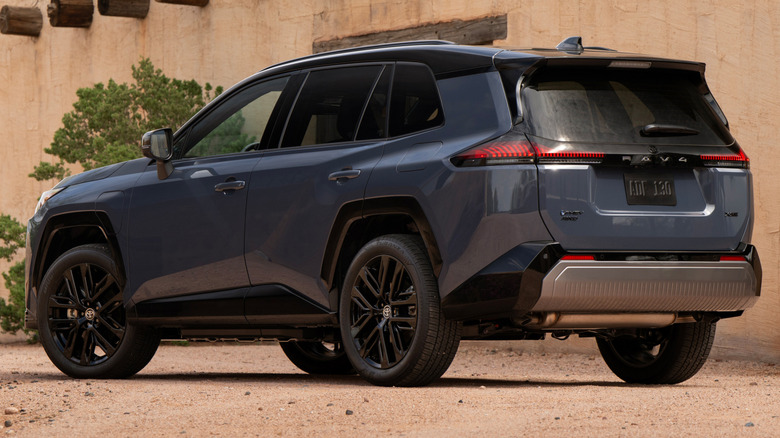 A dark blue 2025 Toyota RAV4 PHEV XSE parked in front of a Southwest-style building