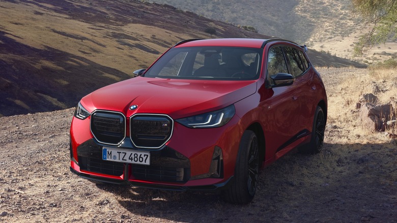 A red BMW X3 driving offroad