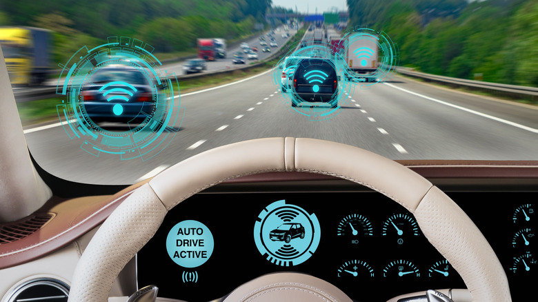 A view from behind the wheel of a car with autonomous drive mode activated, featuring visualizations of proximity data, and other cars.