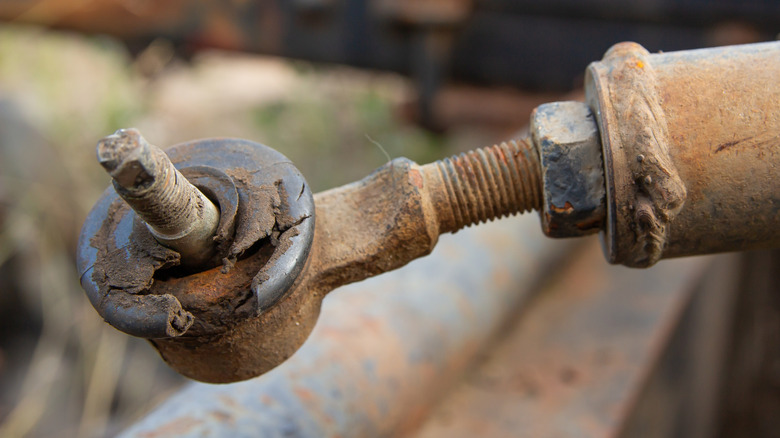 A worn outer tie rod with a damaged ball joint rubber boot