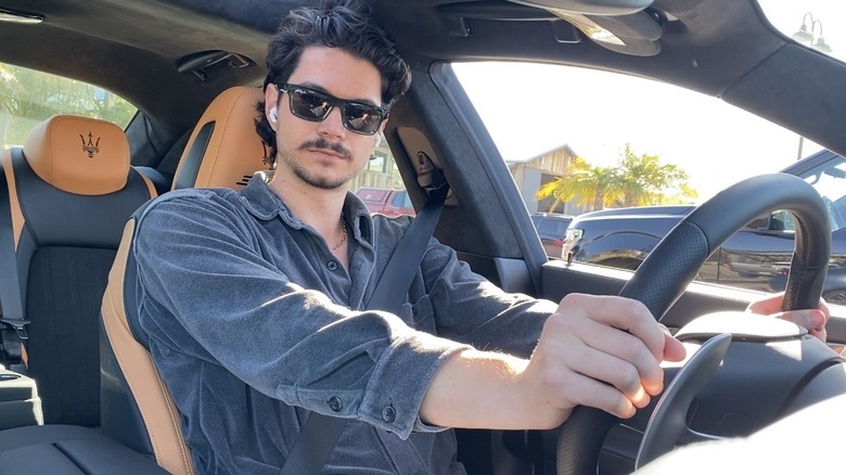 A photo of me in the driver's seat of a Maserati Ghibli 334 Ultima wearing sunglasses showing my headrest adjusted to the top of my ears