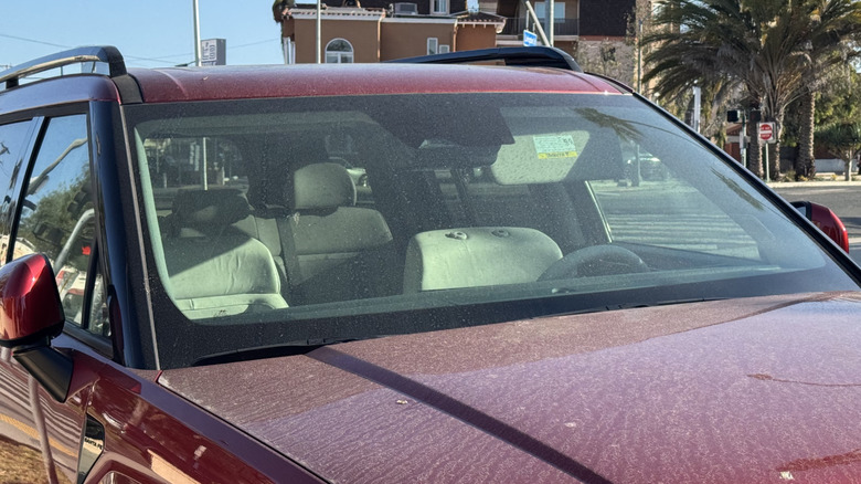 A photo of a dirty red Hyundai Santa Fe showing the front seats with their headrests removed entirely