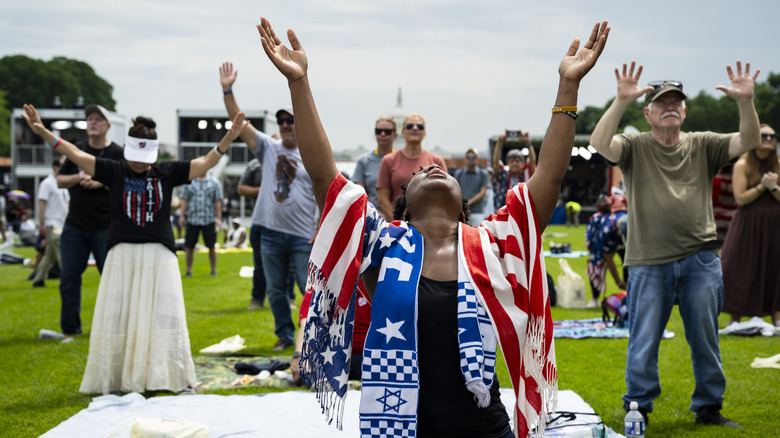 Attendees pray during Rededicate 250: A National Jubilee of Prayer, Praise and Thanksgiving, on the National Mall, on May 17, 2026, in Washington, DC. Leading up to the America 250 celebration later in the year, thousands gathered on the Mall for a day of scripture, testimony, and prayer organized by Freedom250