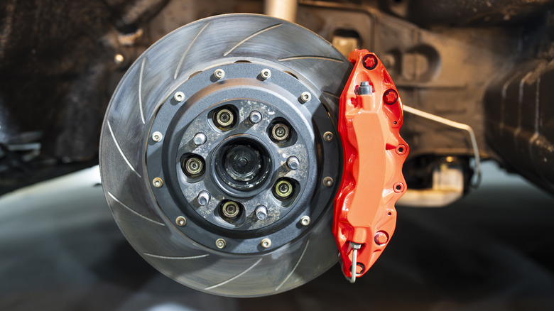 A slotted disc brake with a red brake caliper