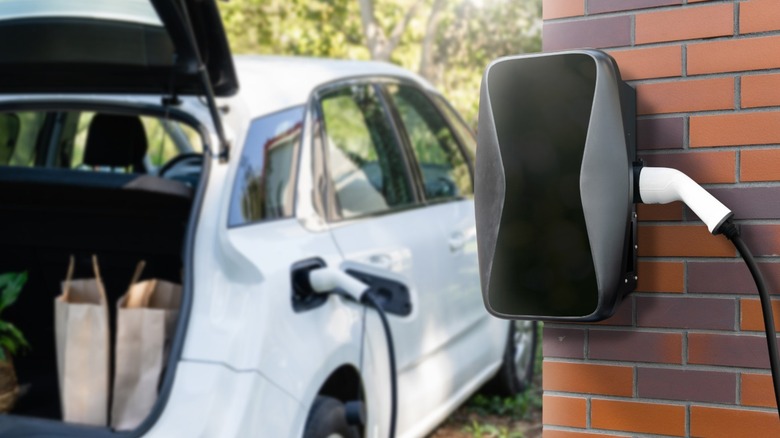 Electric vehicle plugged into wall charger