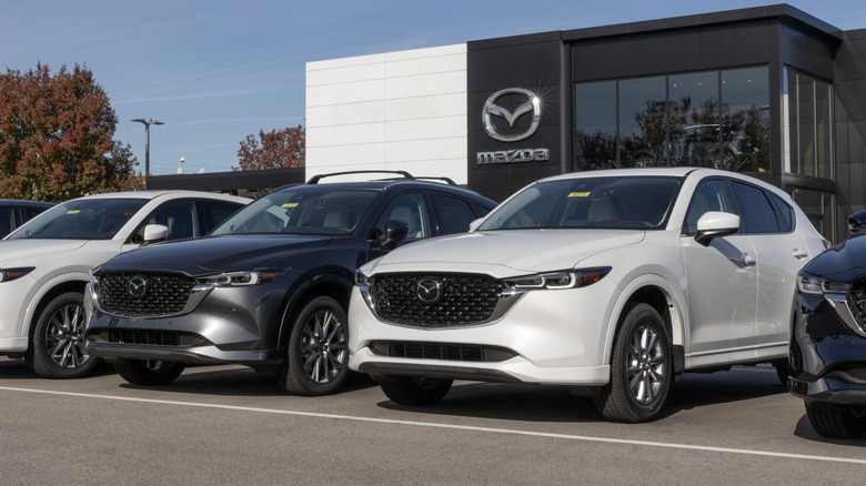 Several Mazdas sit parked on a dealership lot.