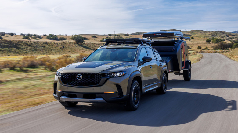 the Mazda CX-50 pulling a trailer on a country road