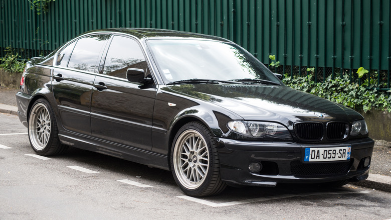 A black BMW 330d parked by a street curb.