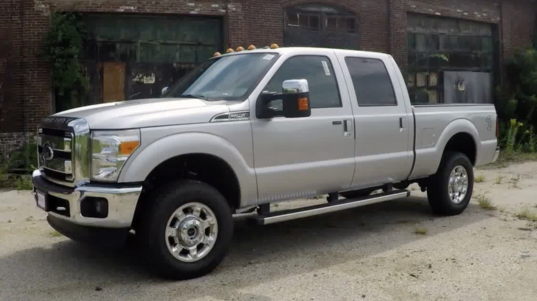 A silver 2016 Ford F-250 Super Duty sits parked outside of a building.