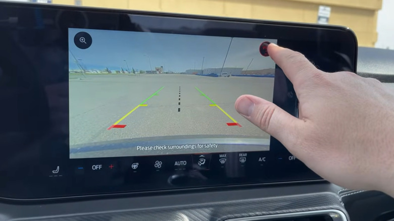 Close up of finger touching control for rearview camera image in Ford Mustang