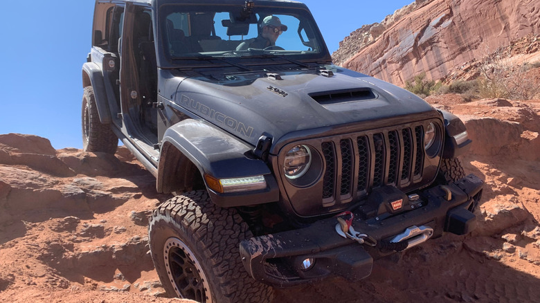 a Jeep Wrangler equipped with a winch driving over rocky terrain