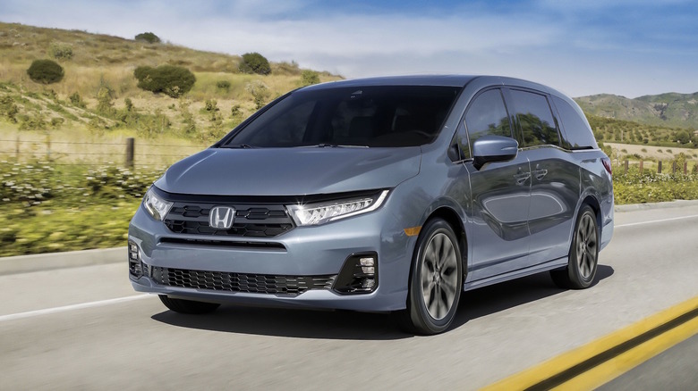 A gray 2026 Honda Odyssey on a roadway in front of hills.