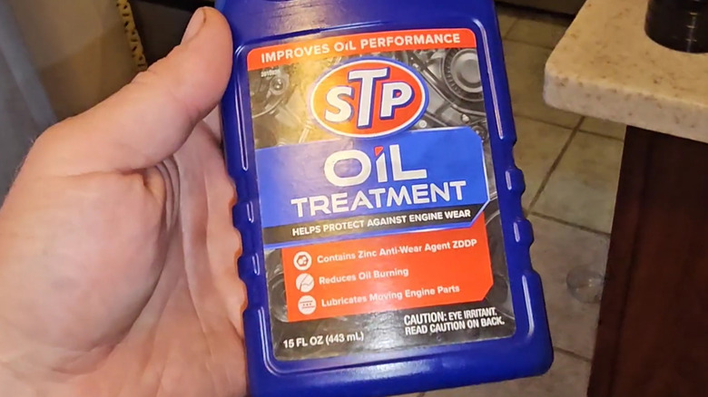 Man holding STP Oil Treatment
