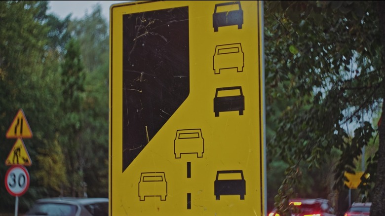 A road sign illustrating how to zipper merge