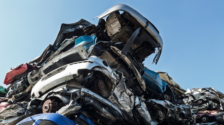 A pile of cars in an auto salvage yard.