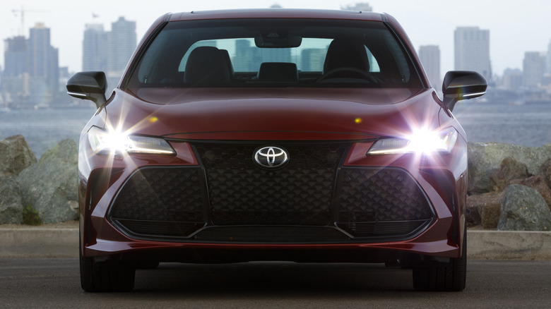 A maroon 2022 Toyota Avalon Touring against a city skyline