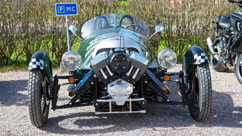 A Morgan 3-wheeler parked next to a motorcycle