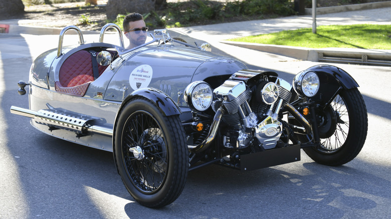 A Morgan 3-wheeler with someone driving inside of it