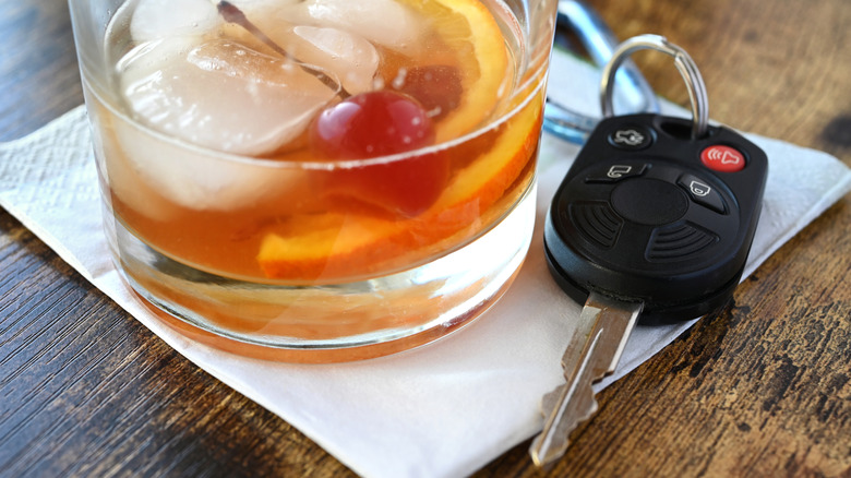A cocktail beverage with car keys next to it on a table